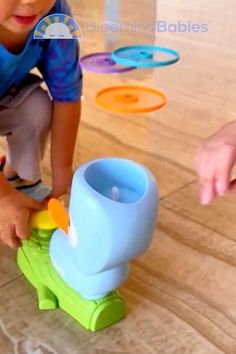 a little boy playing with toys on the floor