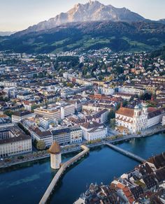 an aerial view of a city with mountains in the background and water running through it