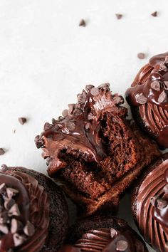 several chocolate cupcakes with one cut in half