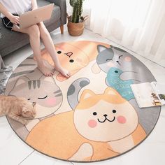 a cat laying on the floor next to a rug with cartoon cats and kittens