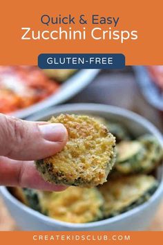 a hand holding up a piece of zucchini crispes over a bowl of other food