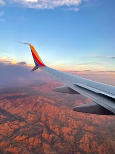 the wing of an airplane as it flies over mountains