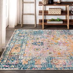 an area rug is shown in front of a shelf with books and vases on it