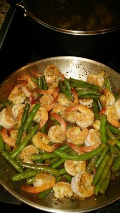 shrimp and green beans in a pan on the stove