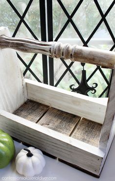 an old wooden crate with two pumpkins and a bat in it sitting on a window sill