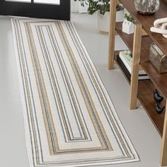 a white rug on the floor in a room with wooden shelves and vases behind it