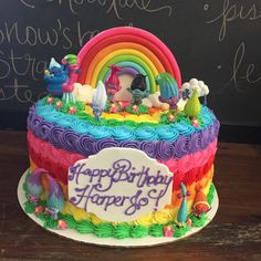 a birthday cake decorated with rainbows and ponies