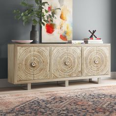 Clean-lined and full of modern style, this sideboard makes a statement whether it holds dinnerware in your dining area or entertaining essentials in your living room. Made from solid wood with a distressed white finish, it rests upon two sled legs and features three engraved medallions for a sleek, boho vibe. We love how the surfaces create a lived-in look, while the three sets of double doors open to plenty of interior storage space. No assembly is required, but we recommend having two people m Acacia Wood Sideboard, Carved Door, Wide Sideboard, Solid Wood Cabinets, Beautiful Cabinet, Carved Doors, Multi Dimensional, Wood Sideboard