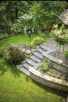 an aerial view of a garden with steps leading up to the lawn and trees in the background