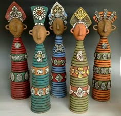 five colorfully painted wooden dolls sitting next to each other