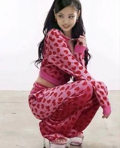 a woman in a red and white polka dot outfit poses for the camera with her legs crossed