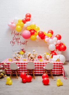 the table is set up for a party with balloons