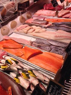 several different types of fish on display at a market