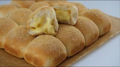 rolls with butter on top sitting on a piece of wax paper, ready to be eaten