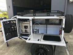 an off - road vehicle is parked in front of a building with its doors open