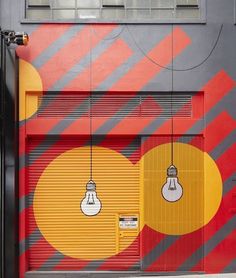 a garage door painted with bright colors and hanging lightbulbs