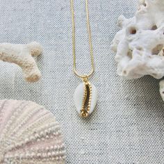 We love this fun and summery, beachy necklace. Answer the siren's song and get one for yourself or someone you love. Would make a great gift for the surfer or beach-lover in your life! A 14k gold electroplated cowrie shell dangles from a lustrous, high quality gold filled snake chain. The perfect summertime accessory! Chain length 16"✦ JEWELRY CARE ✦✧ Warm water and a soft cloth are the best thing you can do to maintain the beauty of your jewelry.✧ Jewelry polishing cloths work great and are non Gold Necklace With Starfish Charm For Beach Season, Gold Starfish Charm Necklace For Beach Season, Dainty Handmade Shell Jewelry, Gold Bohemian Charm Necklaces For Vacation, Gold Shell Necklace With Starfish Charm For Summer, Beachy Cowrie Shell Jewelry For Vacation, Gold Shell Necklace With Starfish Charm For Beach, Gold Cowrie Shell Jewelry For Gift, Cowrie Shell Dangle Jewelry Gift