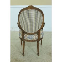 an antique chair with plaid upholstered back and seat cushion, on carpeted floor