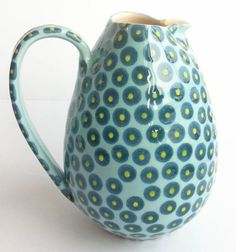 a blue vase with yellow dots on it