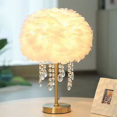 a white lamp sitting on top of a table next to a framed photo and a frame