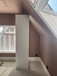 an empty room with white shutters on the windows and carpeted flooring in front of it