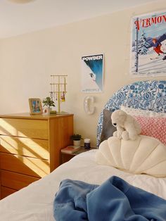 there is a teddy bear on the bed in this bedroom with blue and white decor