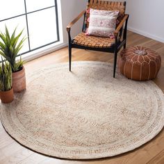 a living room area with a chair, rug and potted plants