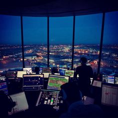 a control room with multiple monitors and other equipment in it at the top of a building