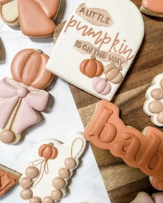 some decorated cookies are on a table with the words little pumpkin is on the way