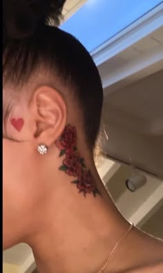 a woman with tattoos on her neck and behind her ear is looking into the distance