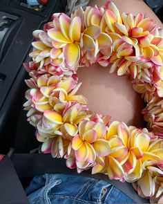 a person is sitting in a car with a wreath on their lap