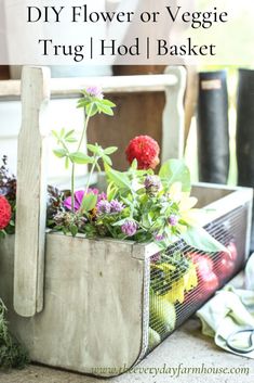 an old basket filled with flowers sitting on top of a table