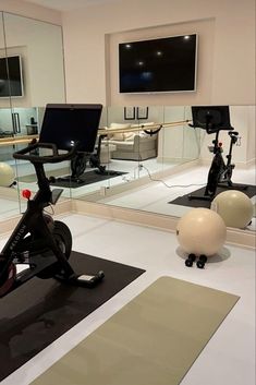 an indoor gym with exercise equipment and mirrors