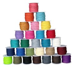 many spools of thread are stacked up in the shape of a pyramid on a white background