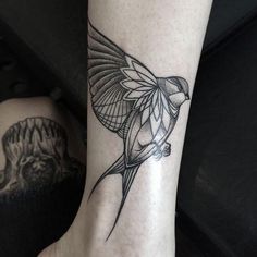 a bird tattoo on the foot of a woman