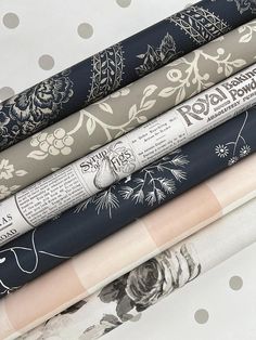 a stack of rolled up wrapping paper on top of each other in various patterns and colors