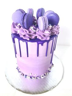 there is a purple cake with macaroons on it