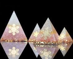 three pink and white pyramids with gold designs on them