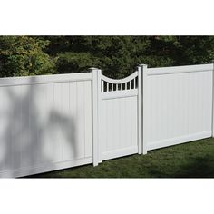 a white vinyl fence in front of some trees