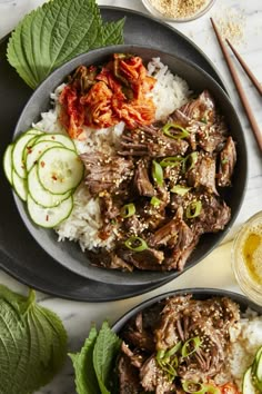 two bowls filled with rice, meat and vegetables