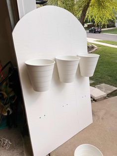 three white buckets sitting on the side of a building