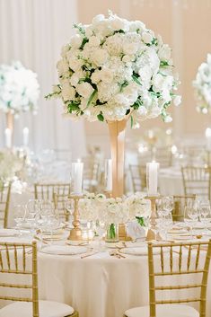 the centerpieces in this wedding reception are all white roses and hydrangeas