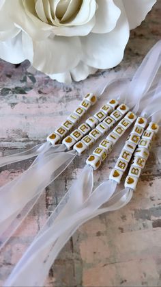 white flowers and ribbon on a table with some sort of bead in the middle