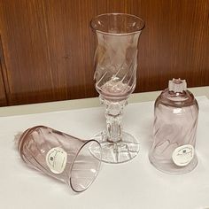 three glass vases sitting on top of a white countertop next to each other