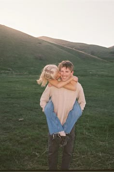 two people hugging each other in a field