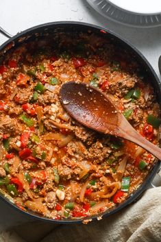 a skillet filled with meat and vegetables on top of a table