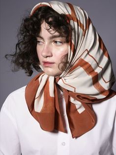 a woman wearing a white shirt and brown scarf