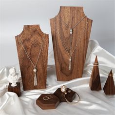 three pieces of jewelry sitting on top of a wooden stand next to other items and accessories