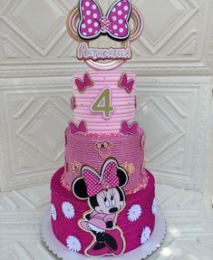 a three tiered cake with minnie mouse on it's top and the number four