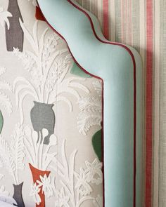 an upholstered headboard with colorful wallpaper and animal designs on it's sides